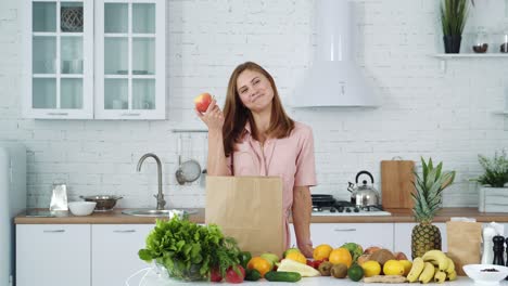 woman unpacks vegetables and fruits from a supermarket bag. girl at home in a white kitchen