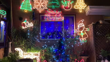 Tiro-Inclinado-Hacia-Arriba-De-Las-Luces-Navideñas-Fuera-De-Una-Casa-De-Londres-Por-La-Noche