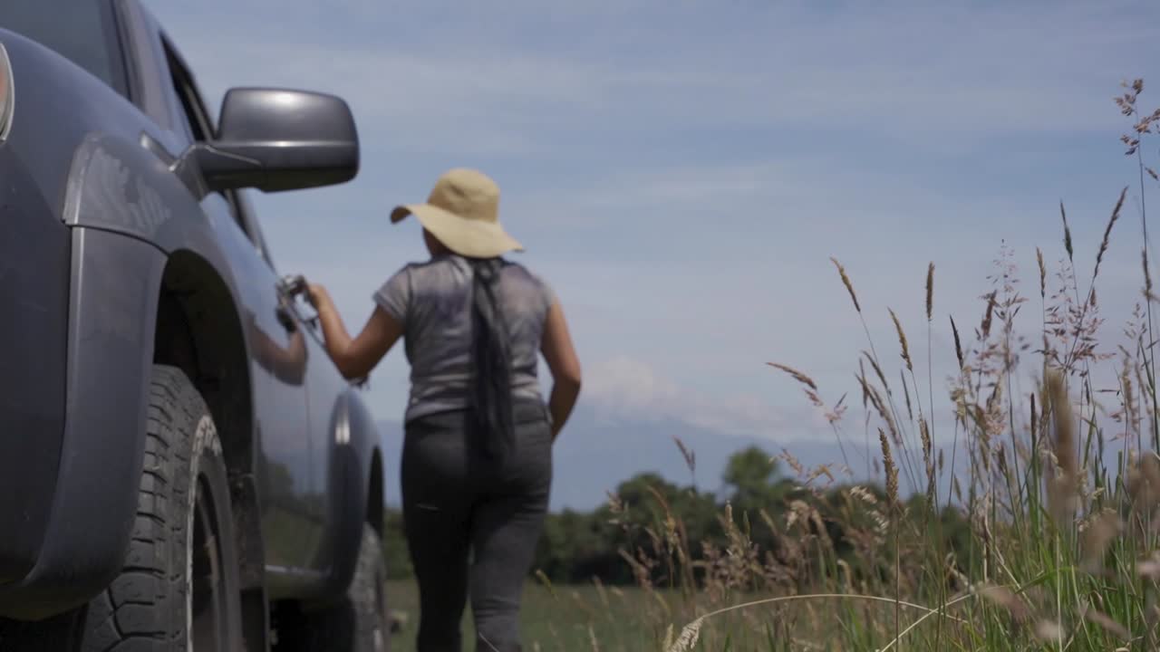 mulher em botas de trabalho andando em torno de sua colheita