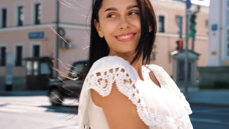 smiling woman in a white dress on a city street