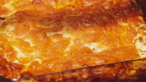 knife cutting into crispy golden melted cheese lasagna top. cooked italian dish ready to portion and serve after cooking in hot oven. bolognese sauce filled pasta based food
