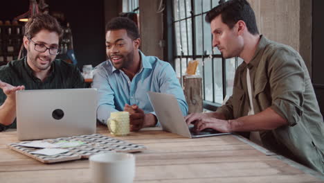 Tres-Diseñadores-Masculinos-Reunidos-Usando-Una-Computadora-Portátil.