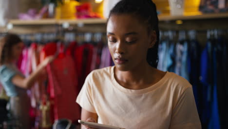 Besitzerin-Oder-Arbeiterin-In-Einem-Modebekleidungsgeschäft-überprüft-Den-Lagerbestand-Mit-Einem-Digitalen-Tablet