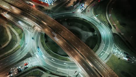 aerial drone time lapse car traffic jam roundabout circle interchange road at night, top view junction highway intersection in evening. timelapse cars driving busy junction crossroad fast motion