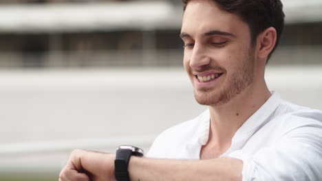 Portrait-of-young-business-man-checking-notifications-on-smart-watch-outdoor