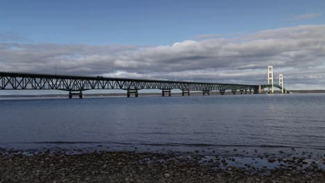 Zeitraffervideo-Der-Mackinac-Bridge-über-Der-Mackinacstraße-In-Michigan-Mit-Wellen,-Fahrenden-Fahrzeugen-Und-Ziehenden-Wolken