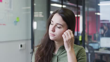 Porträt-Einer-Kaukasischen-Geschäftsfrau,-Die-Ihr-Haar-Hinters-Ohr-Steckt