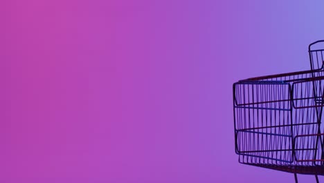 Video-of-shopping-trolley-with-copy-space-over-neon-purple-background