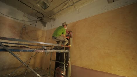 el hombre del constructor cortando la persecución eléctrica en la pared de hormigón con la circulación vio la perforación de la corona de diamantes.
