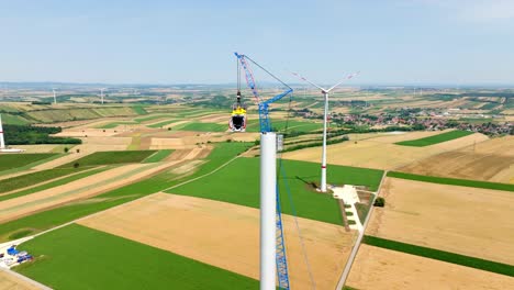 windmill construction in summer field - aerial drone shot