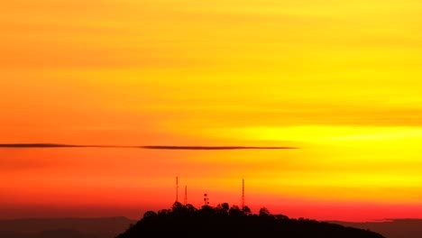 Inclinación-Lenta-Hacia-Abajo-En-La-Silueta-De-Las-Torres-De-Comunicaciones-De-Radio-Contra-La-Vibrante-Puesta-De-Sol-Naranja