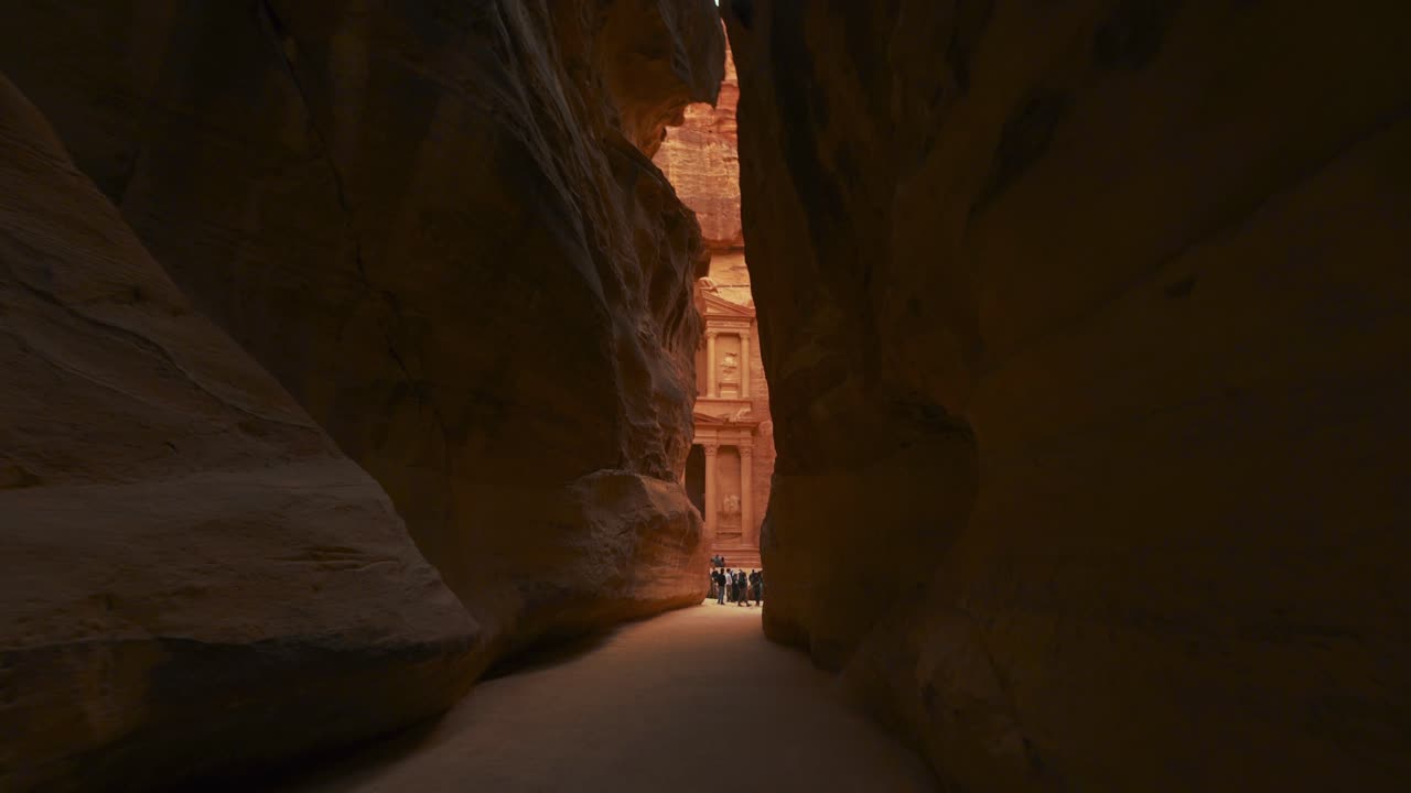 caminando hacia el tesoro a través del siq en petra, patrimonio histórico de la unesco tallado en piedra arenisca en jordania