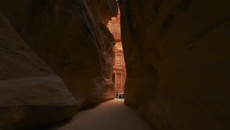 walking toward the treasury through the siq at petra, historic unesco heritage site carved into sandstone in jordan