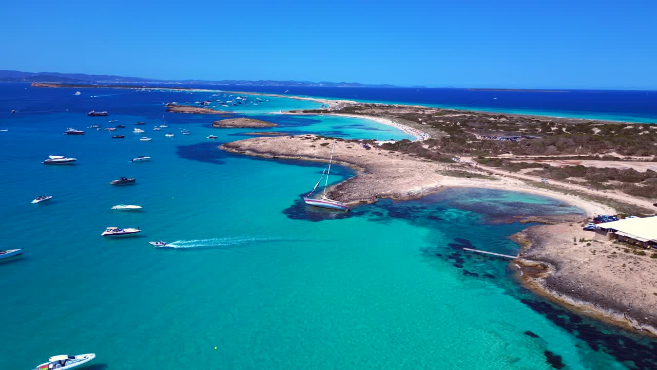Sailboat stranded on cliff near the coast of Formentera Island, Spain, during a summer sunny day. Unbelievable aerial view flight descending drone