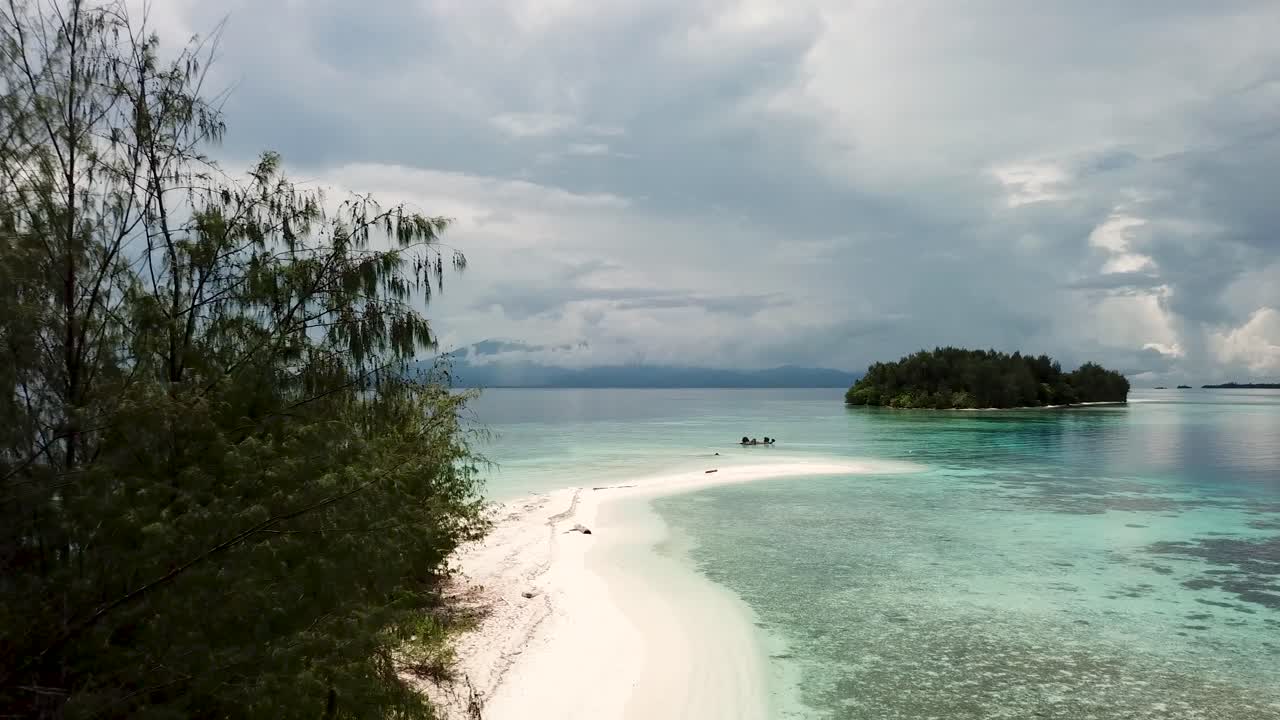 Drone shot of Lumbaria Island, also known as Kennedy Island where John F. Kennedy stranded in World War 2. Drone flying along a white sandy beach