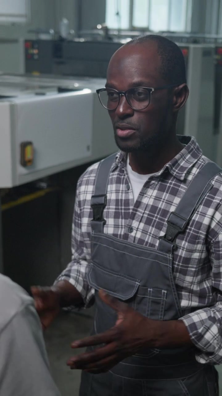 African American Factory Technician Shaking Hands and Talking with Colleague