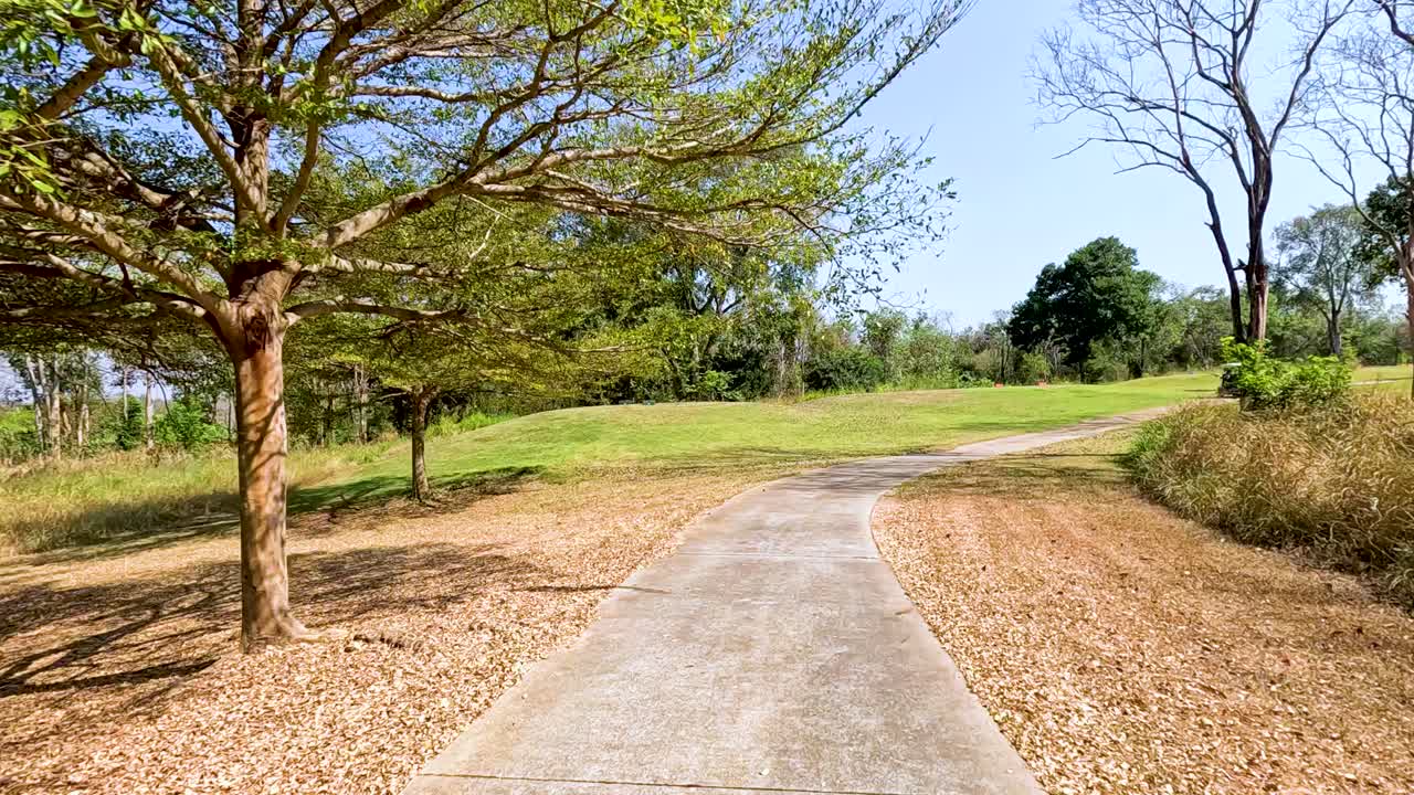 Scenic golf course pathway with trees and greenery