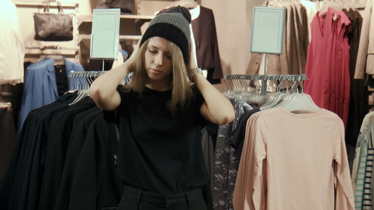 A woman wearing a hat in a clothing store