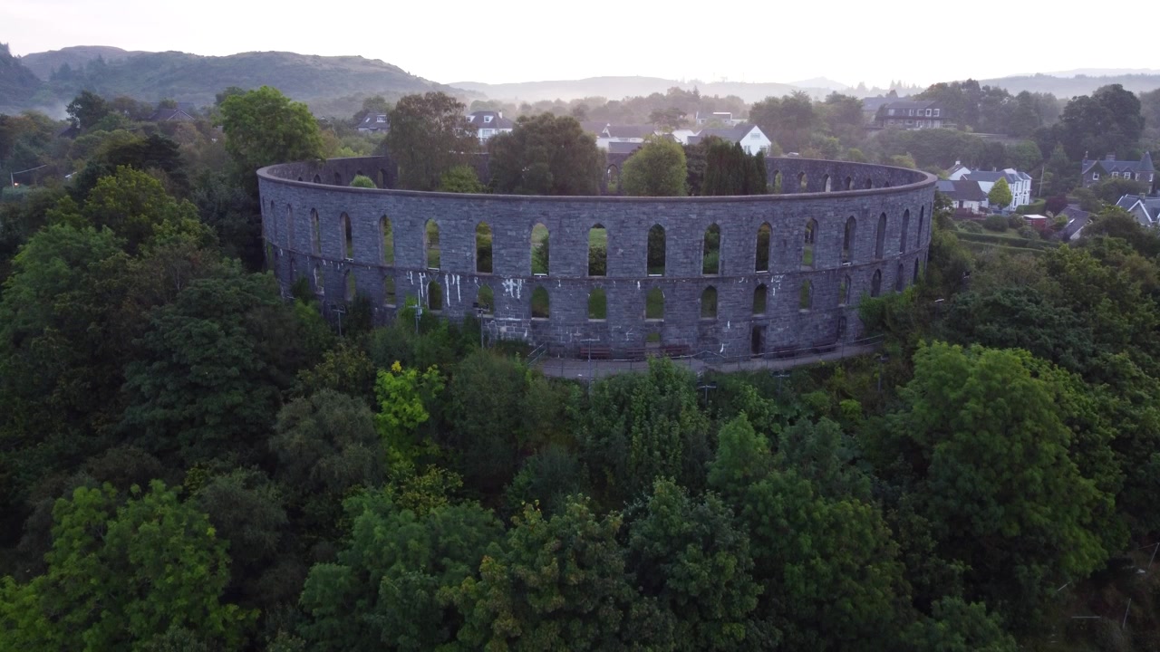 McCaig's Tower and Battery Hill in Oban, Seaside Town on West Coast of Scotland, Aerial 4K HD Footage Rising Up