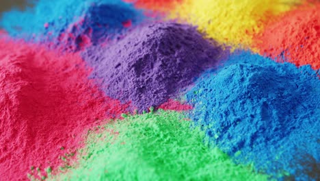 video of close up of multi coloured powders with copy space on black background