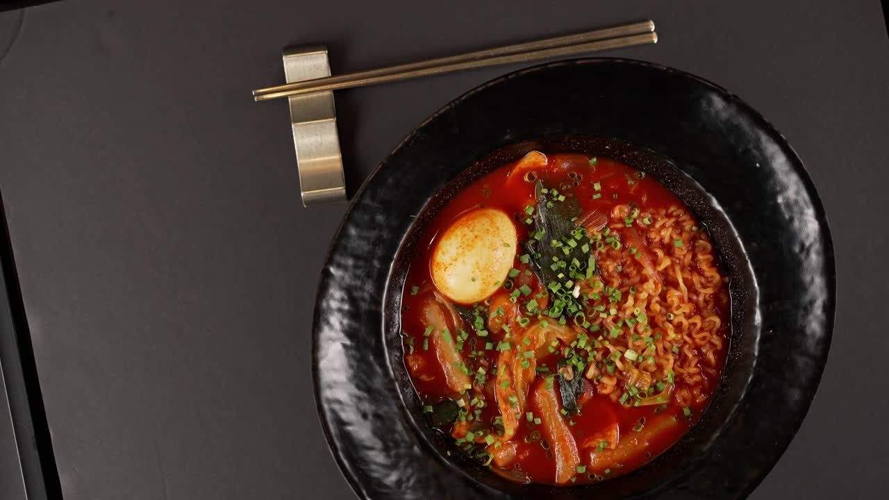 A spicy, rich broth with chewy rice cakes, noodles, fish cakes, and a soft-boiled egg. 매콤한 국물에 쫄깃한 떡, 면, 어묵, 반숙 계란이 조화를 이루는 한 그릇.