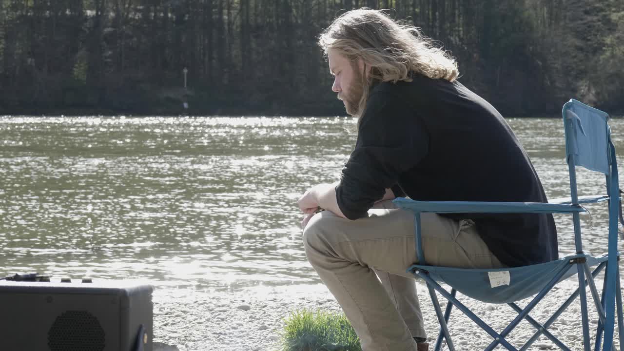 그 불꽃을 더 크게 만들기 위해 신문을 준비하고 있는 집중된 젊은이