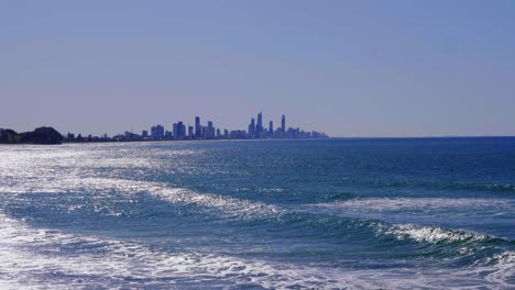 olas azules en la playa de burleigh heads - horizonte de la costa dorada en la distancia - queensland, australia