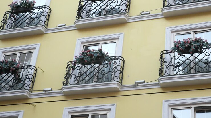 Edificio giallo con balconi e ringhiere in ferro battuto