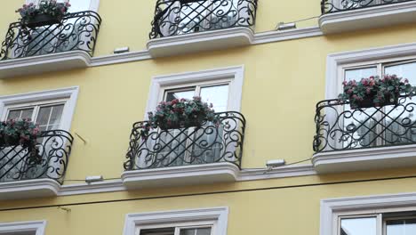 yellow building with balconies and wrought iron railings