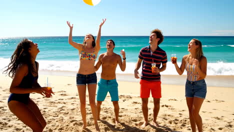 group of friends playing with a beach ball on a sunny beach