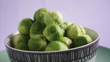 Close-Up-of-Fresh-Brussel-Sprouts-rotating-on-blue-background