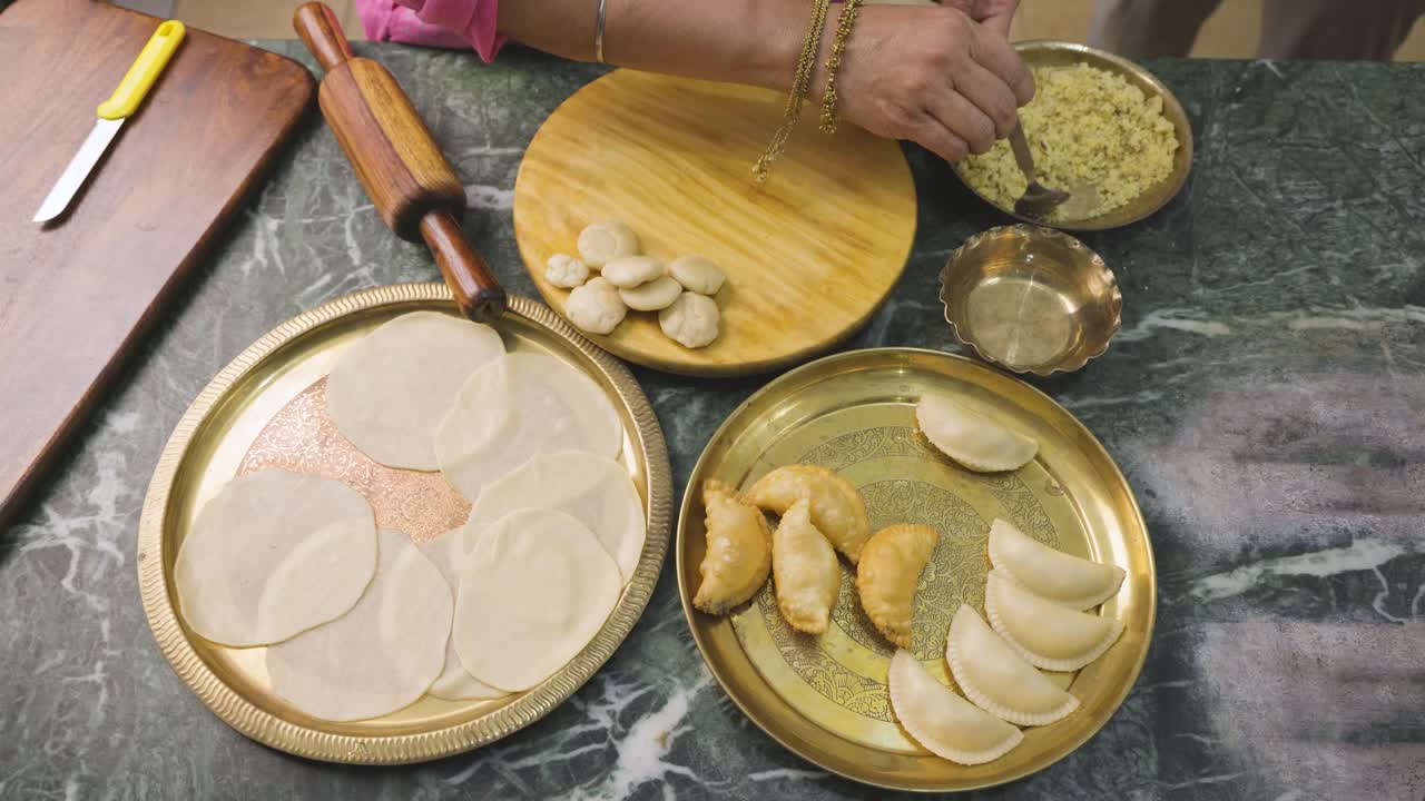 una mujer india preparando gujia, un bocadillo popular indio especialmente hecho en el festival de colores de holi