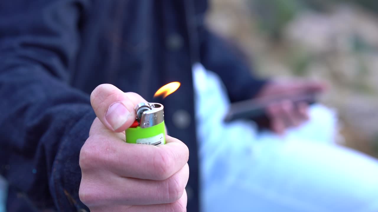 담배를 피우기 위해 라이터를 켠다.