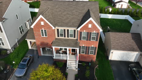 Traditional-new-two-story-modern-brick-family-home-with-American-flag-at-porch,-two-car-garage