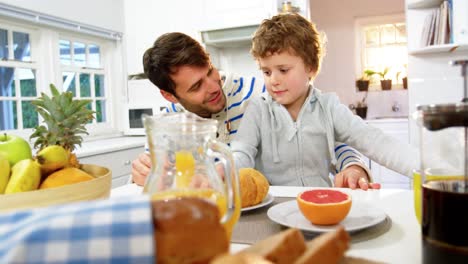 father and son having breakfast in the kitchen