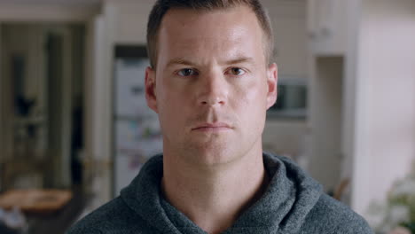 portrait-attractive-man-looking-at-camera-with-serious-expression-at-home