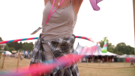 girl hula-hooping at a music festival, slow motion