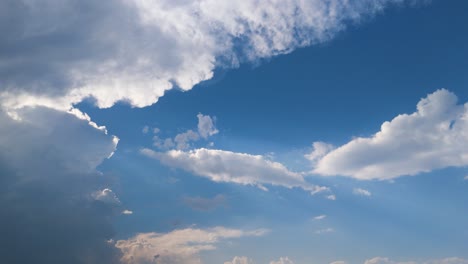 white cumulus clouds in slow motion, layered blue sky