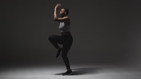 Foto-De-Estudio-De-Una-Mujer-Vestida-Con-Ropa-De-Gimnasio-Haciendo-Ejercicio-Corriendo-En-El-Lugar-4