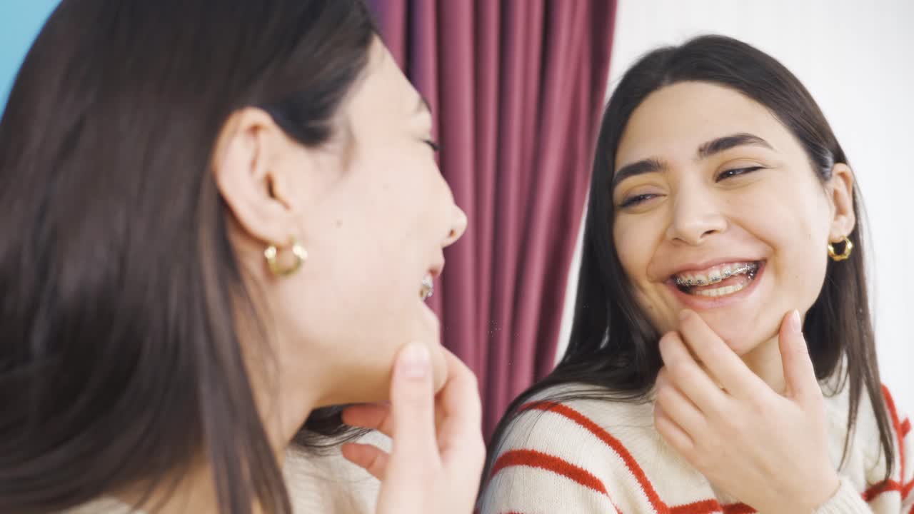 거울에 자신의 브레이크를 보는 소녀는 행복합니다.