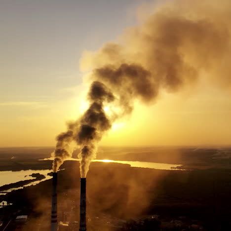 industrial pipes with thick smoke at sunset. two large pipes produce chemical smoke in the air on nature background. environmental pollution.
