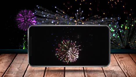 Animation-of-fireworks-exploding-displayed-on-smartphone-screen-and-on-black-background