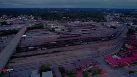 Aerial-Columbus,-GA:-railway-yard,-highway,-and-cityscape-at-twilight