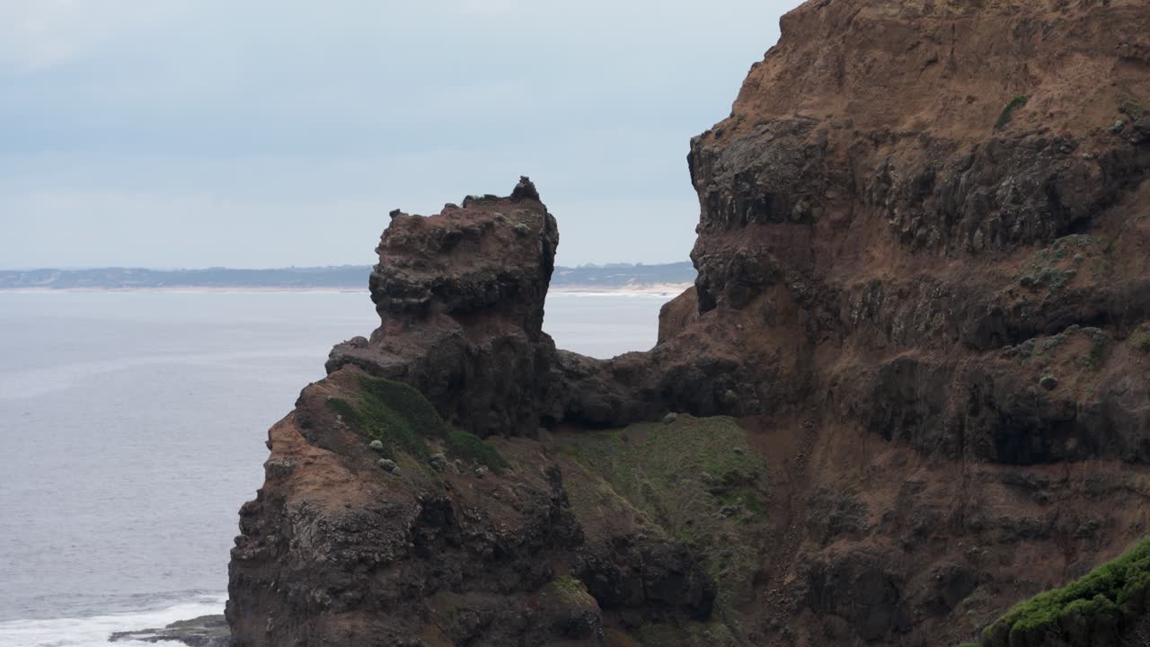 A stunning rock formation nestled on the side of a steep cliff, capturing the rugged beauty of nature in a dramatic landscape.