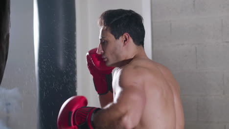 strong male boxer hitting punching bag with force