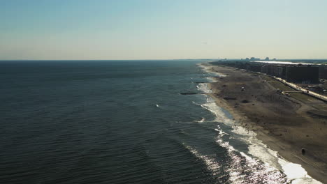 descend - dolly forward down to ocean below - towards setting sun shine glistening on the water in long beach, new york