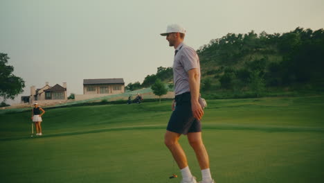 male golfer walks across the putting green at sunset, bathed in golden light. a quiet, cinematic moment that captures the serenity and rhythm of the game during golden hour on the course.