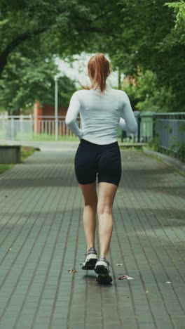 a woman jogging along a tree-lined pathway, embracing a healthy lifestyle and enjoying an active outdoor exercise routine