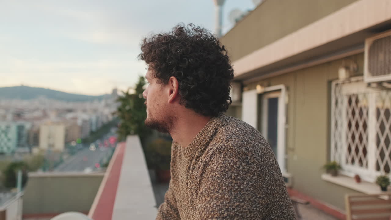 Man looking at city view from balcony