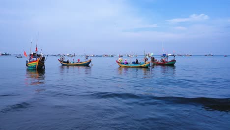 A-group-of-small,-brightly-colored-Vietnamese-fishing-boat-return-to-shore-after-a-night-at-sea